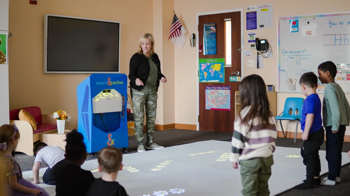 Children stand around an interactive projection floor