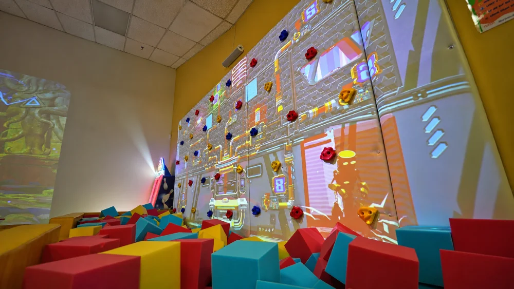 Interactive rock climbing wall with game projections