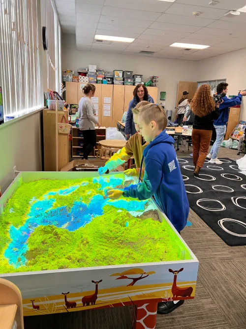 Children playing with an AR interactive sandbox