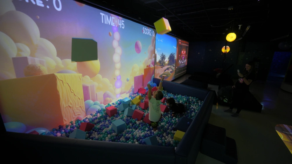 Kids playing interactive throwing game in ball pit