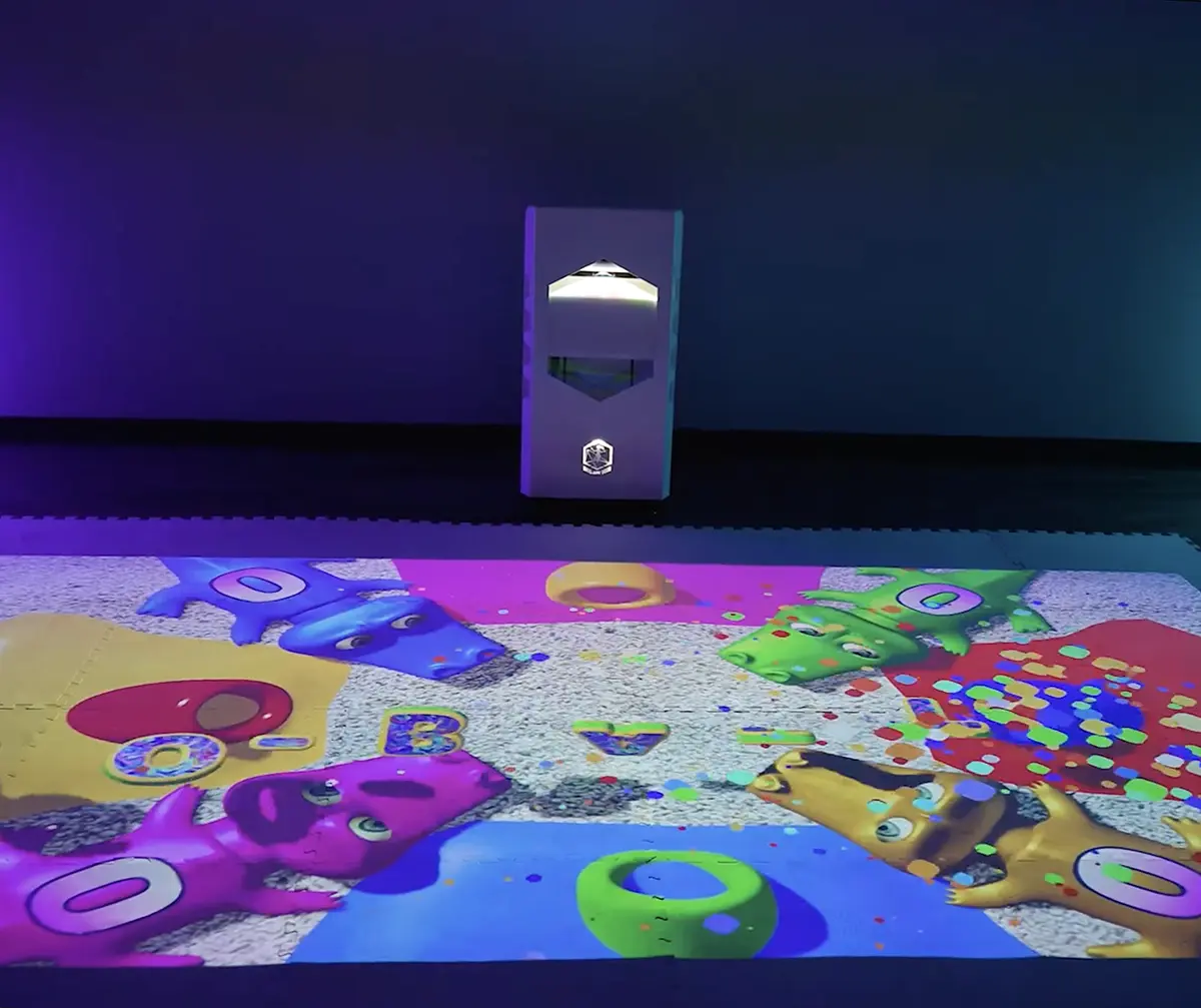 Interactive floor projector projecting a colorful crocodile-themed educational game onto the floor