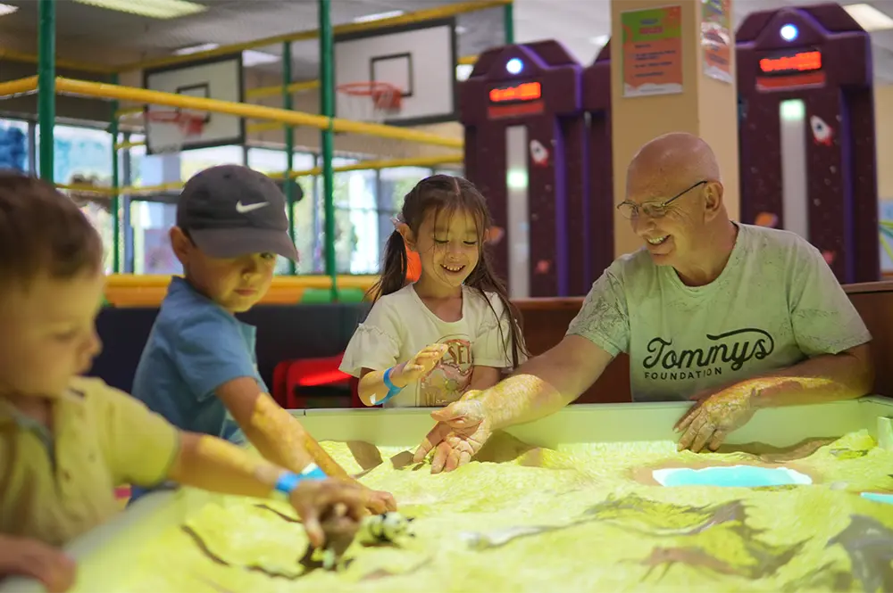 Family playing with interactive sandbox