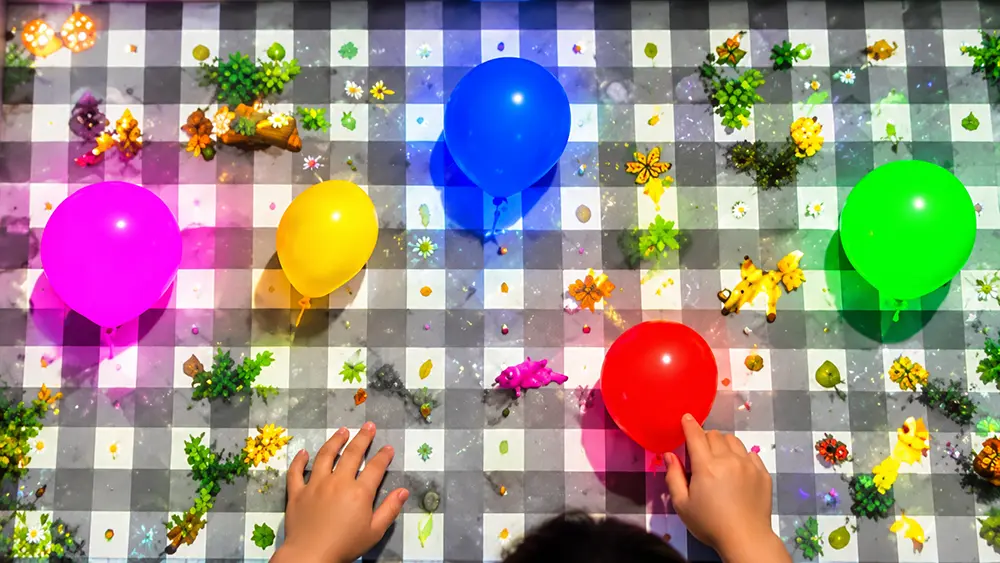 Sandbox Balloons interactive sandbox preview with colorful balloons floating above a child’s hands